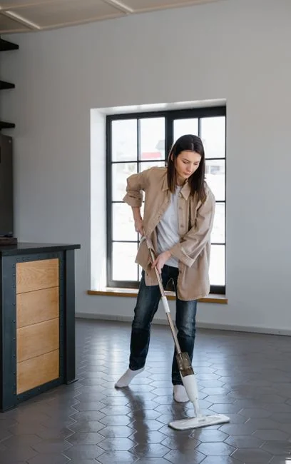 A pair working together to carry a sofa while settling into a new apartment.